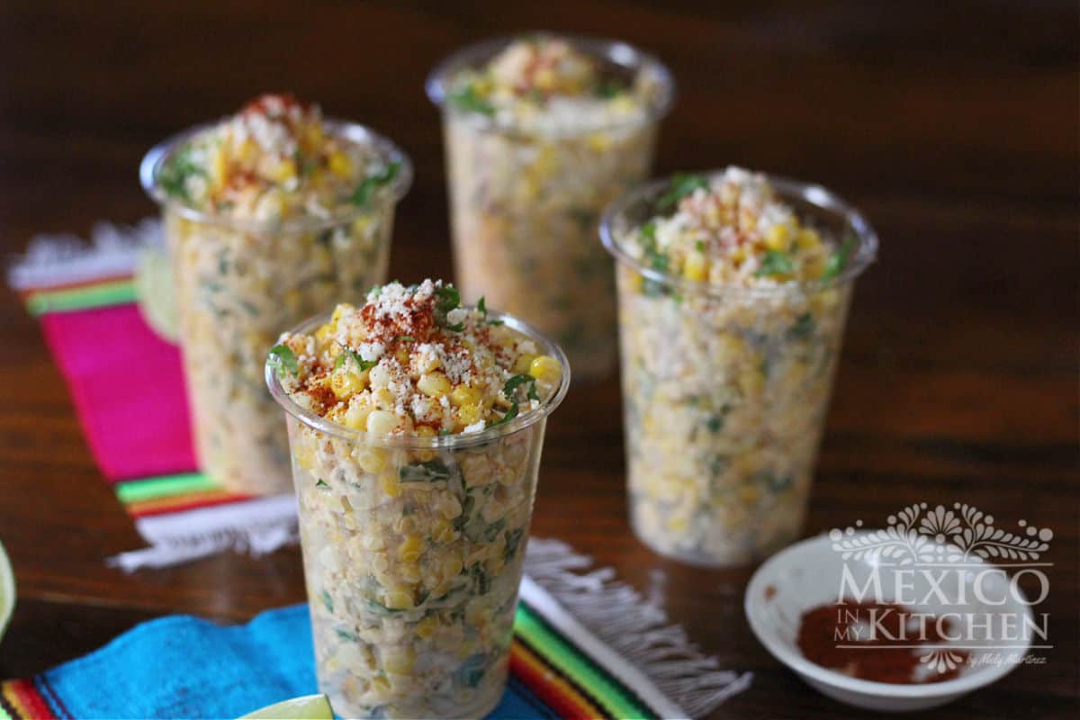 Corn kernels in cups, garnished with Mexican crema, cotija cheese and chili powder. 