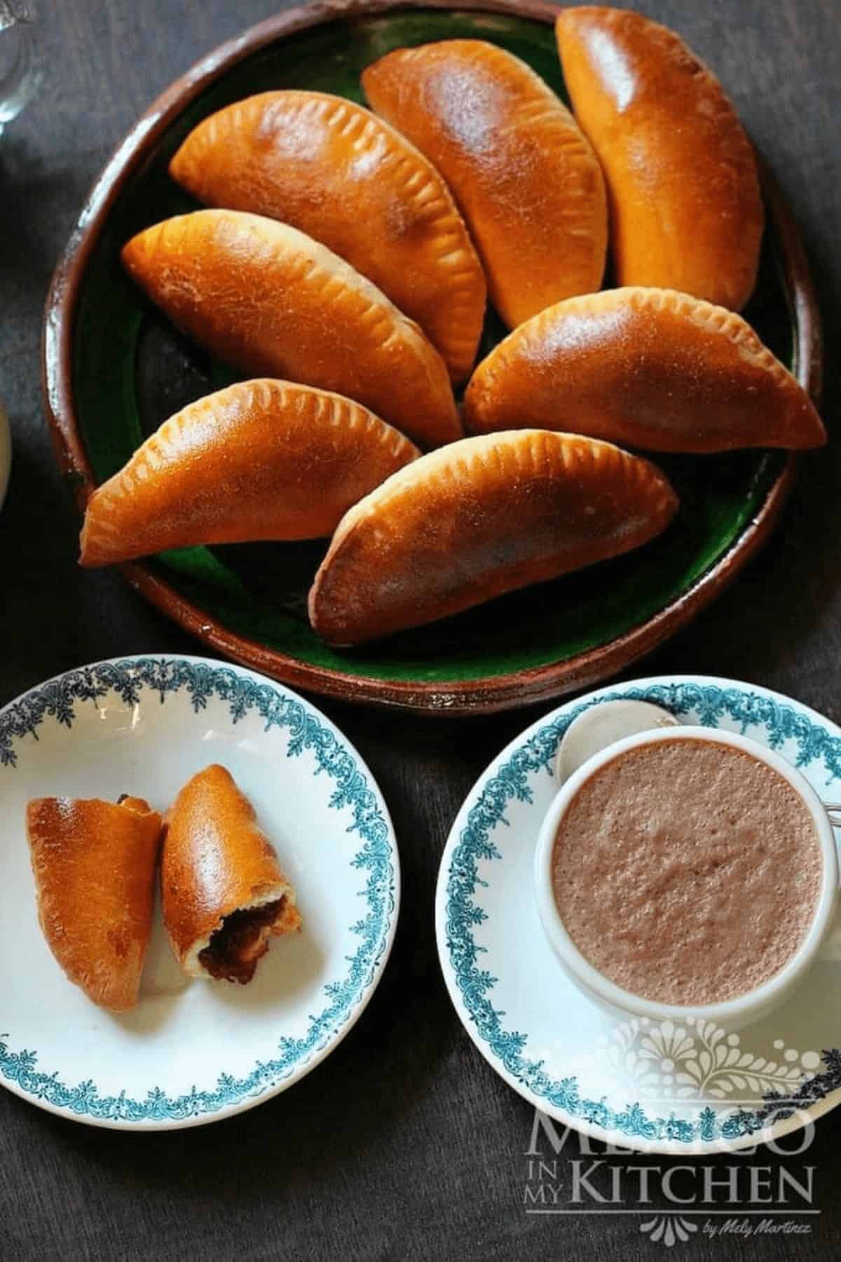 Golden Pumpkin empanadas on a platter served with hot chocolate.
