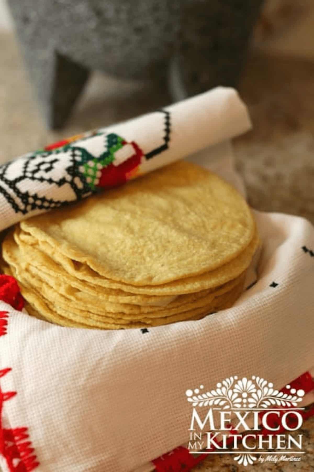 A stack of homemade corn tortillas on a red napkin.