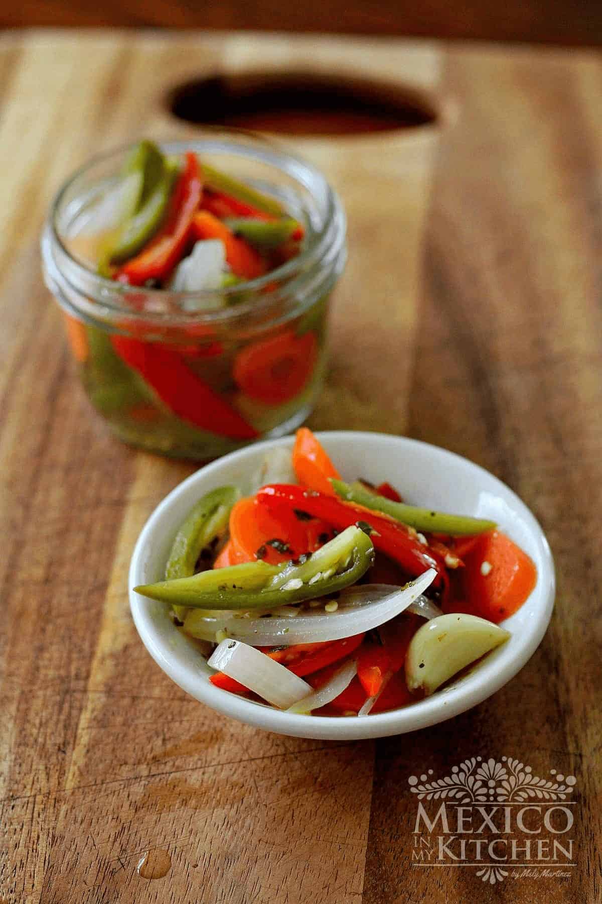 Pickled jalapeños served in a bowl and a jar.
