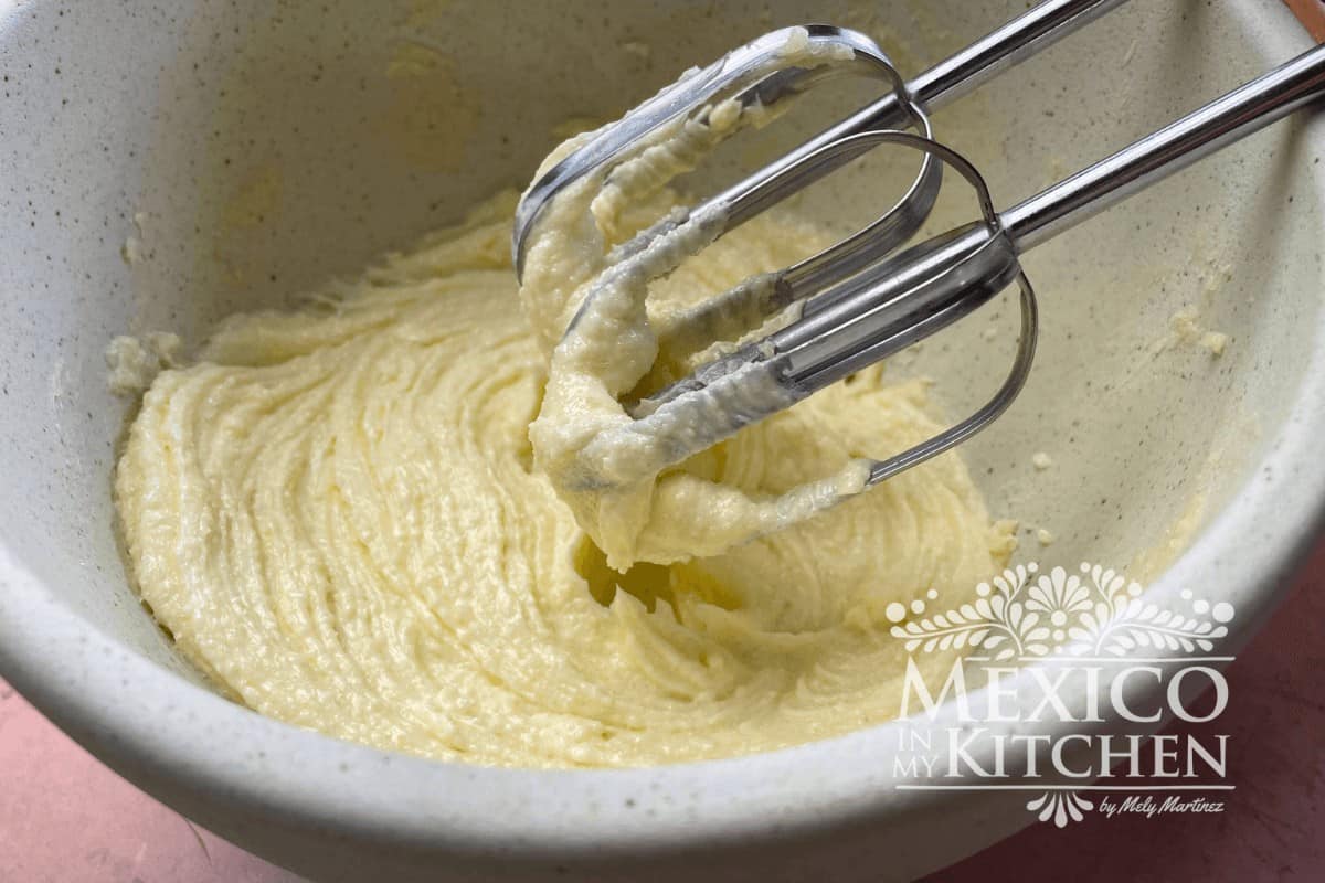 The butter mixture is beaten with a hand mixer.