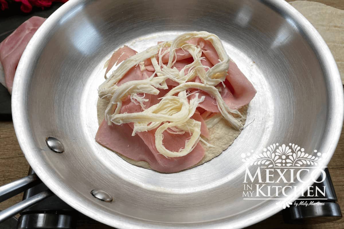 Tortilla topped with ham and cheese.