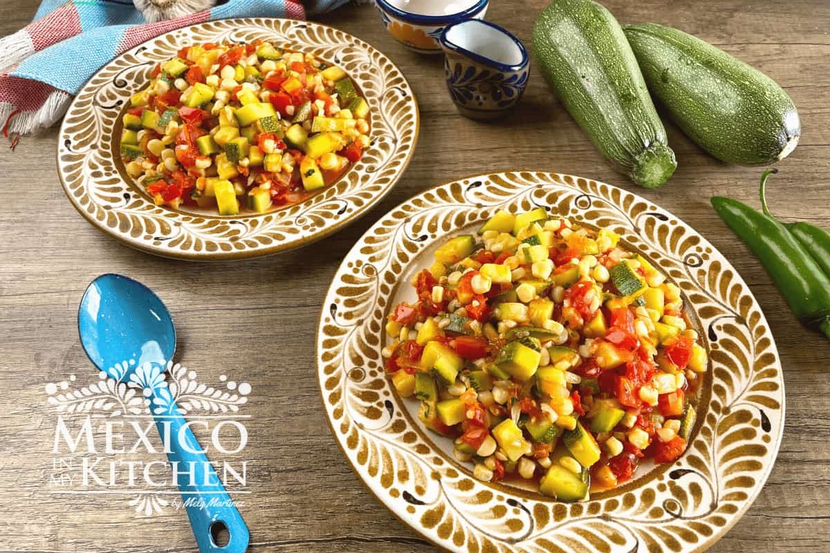 Serving of Mexican zucchini and corn  (calabacitas con elote) on platters