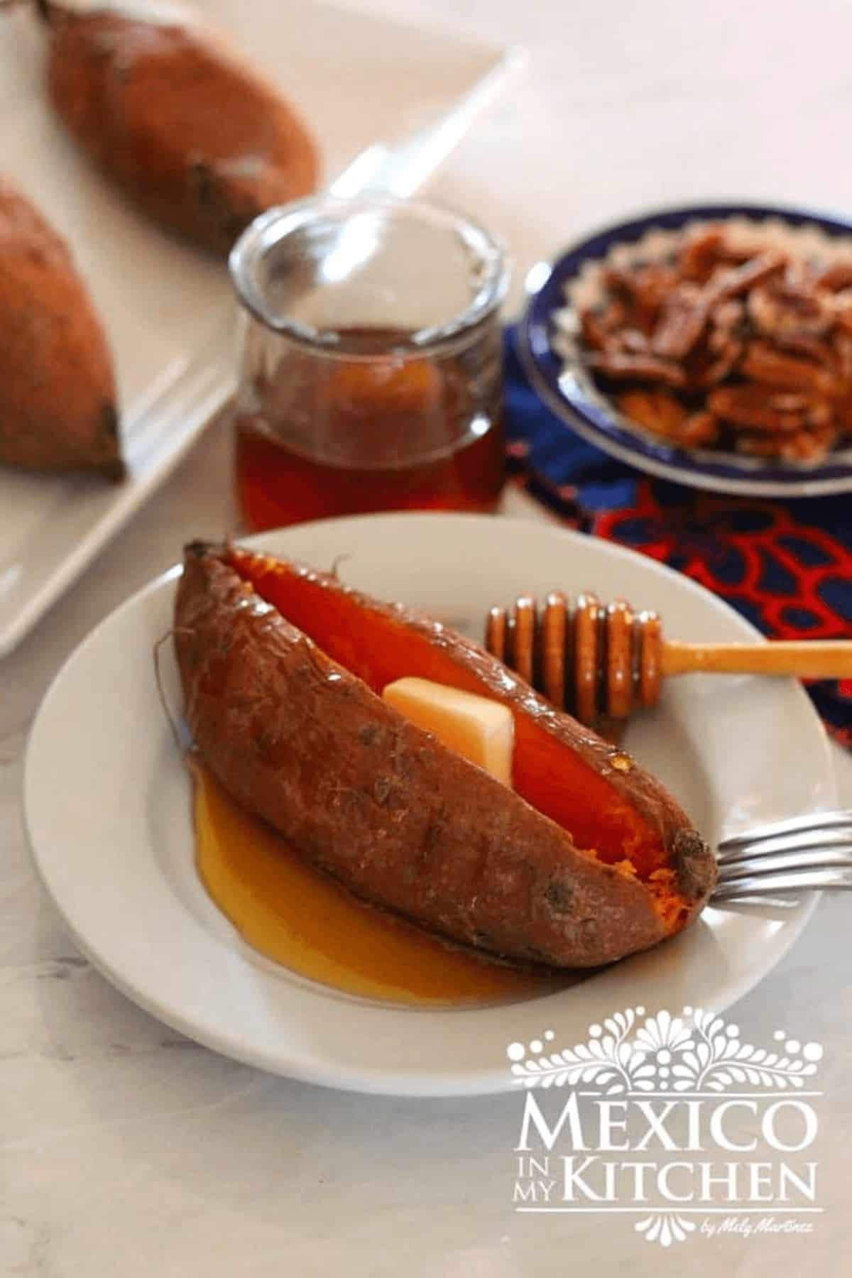 Sweet potato served on a plate, topped with butter and honey.
