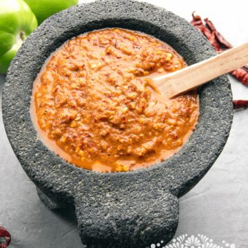 Roasted tomatillos and arbol pepper salsa in a molcajete