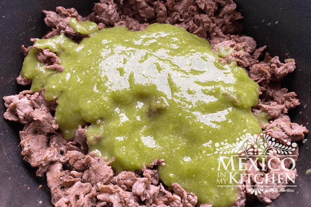 Cooked beef topped with green sauce for carne en su jugo