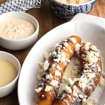 Fried plantains served in a platter and topped with condensed milk and queso fresco.