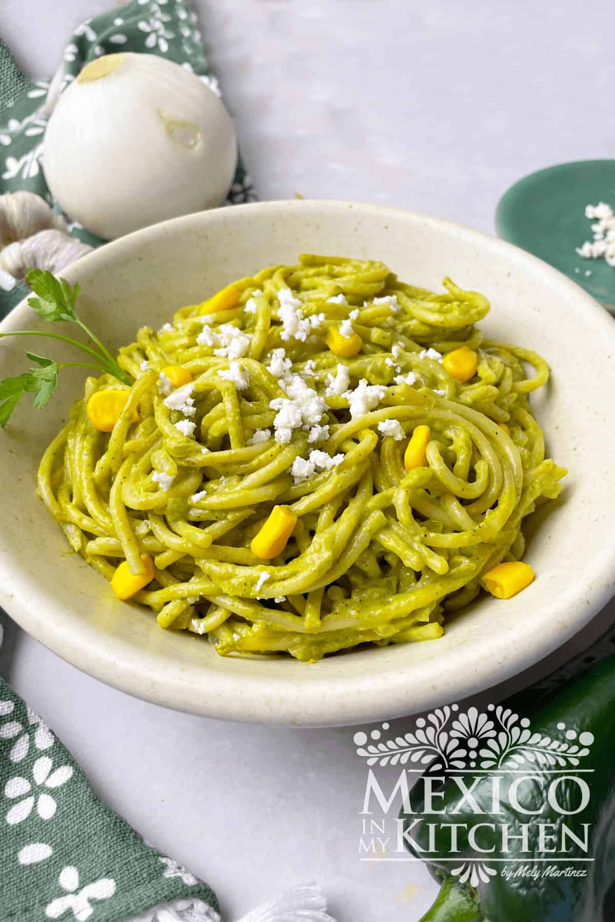 Spaghetti Verde topped with corn, queso fresco and cilantro in a bowl.