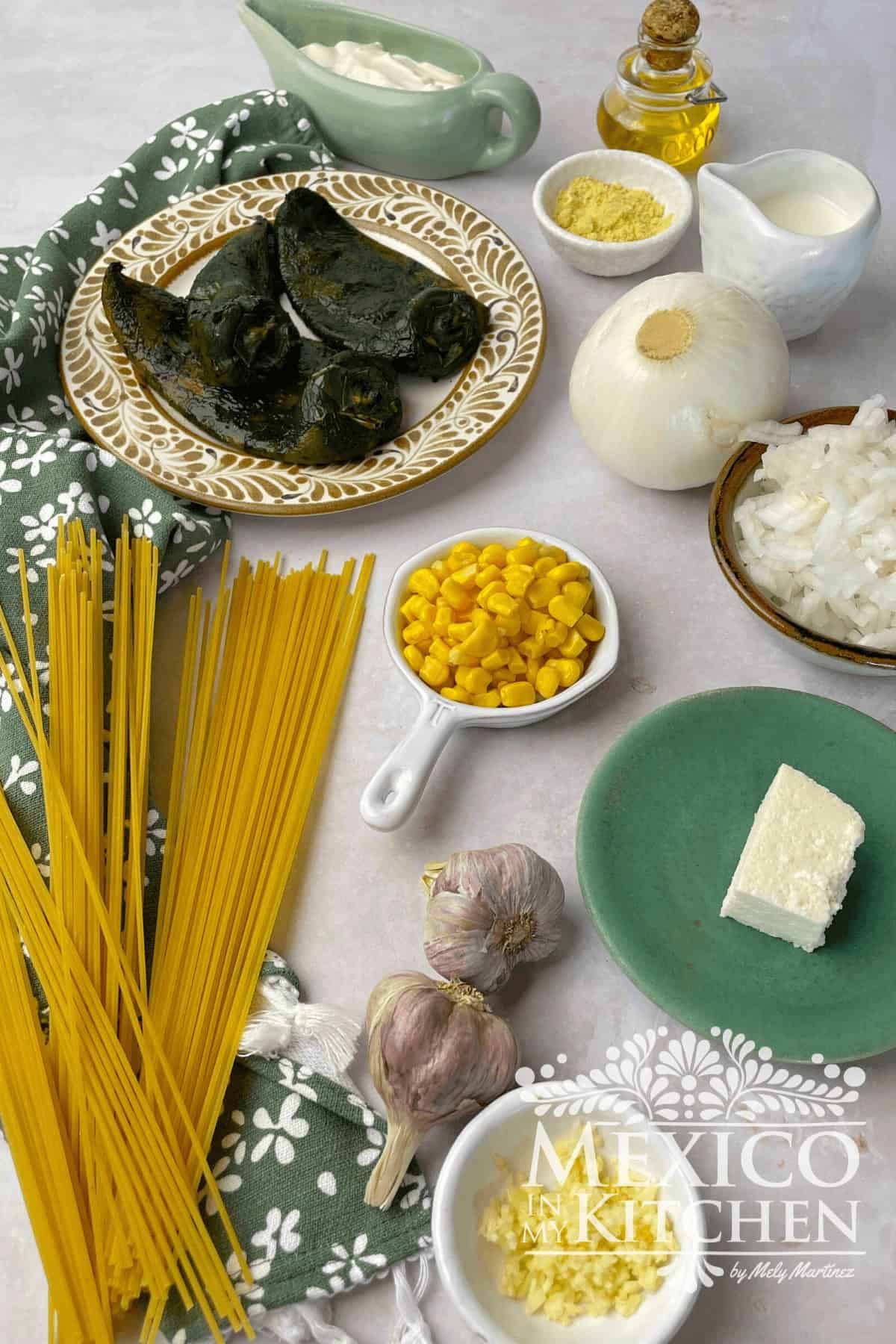 Photo if ingredients like, poblano peppers, spaghetti, Mexican crema and more displayed in a table