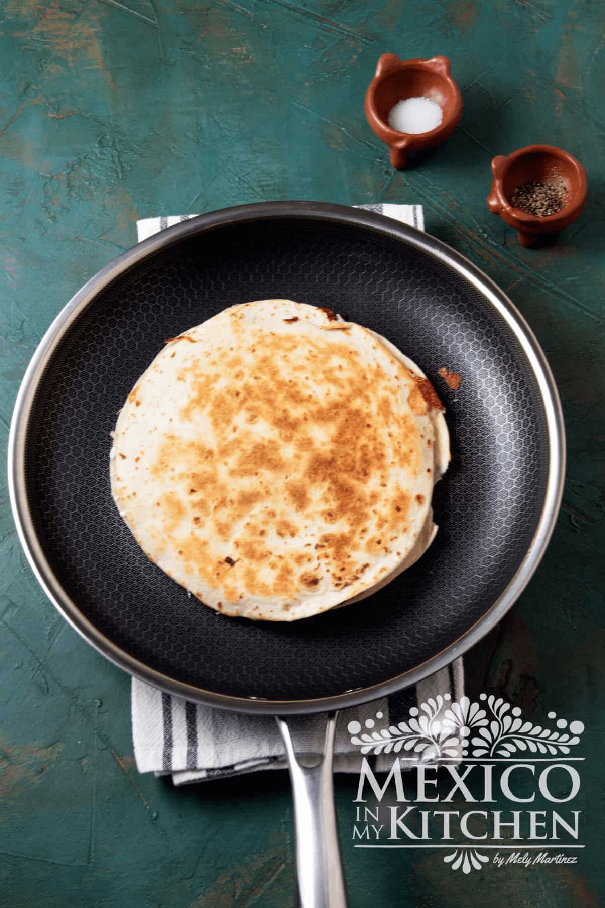 Toasted flour tortilla on a frying pan.