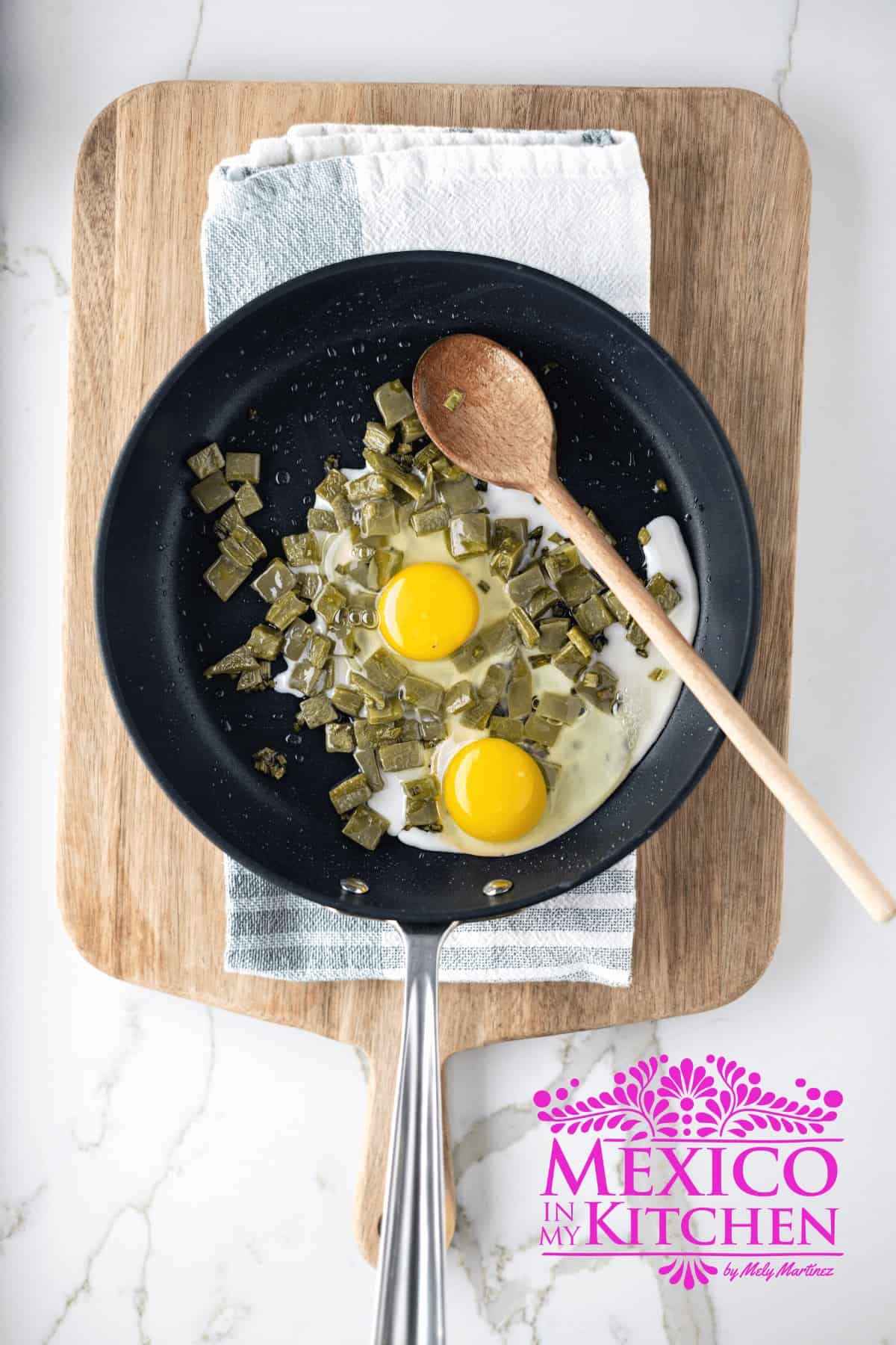 Cooking cactus paddles and eggs on a frying pan.