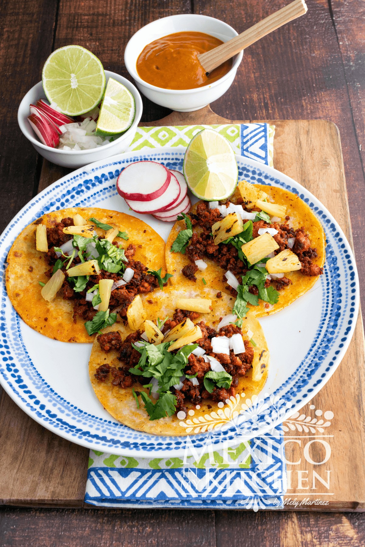 Chorizo tacos topped with cilantro, white onions, and pineapple.