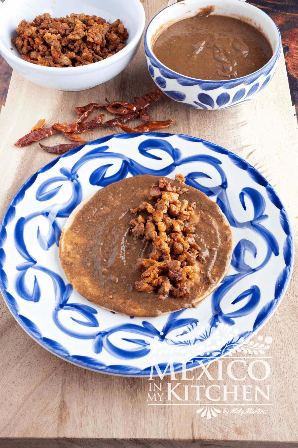 Corn tortilla cover in bean sauce and topped with chorizo.
