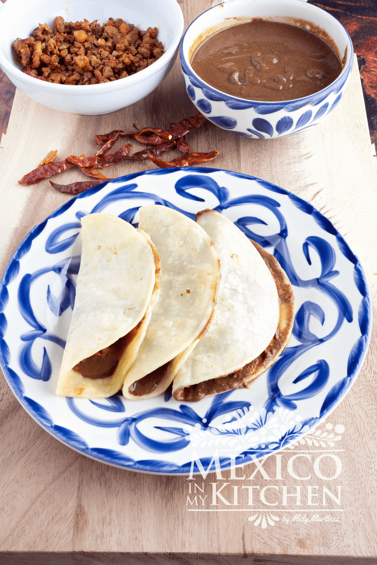Folded corn tortillas filled with bean sauce and chorizo
