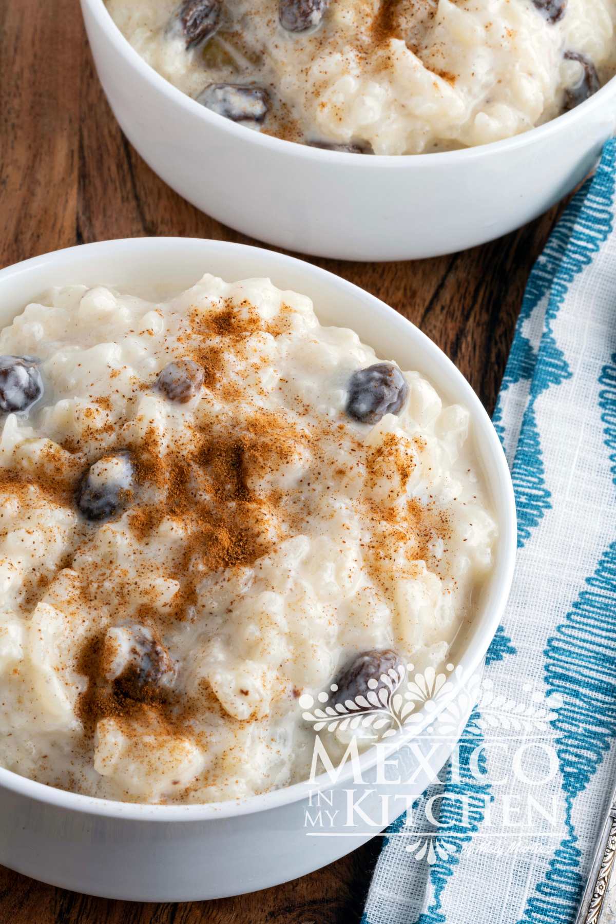 Arroz con leche in white serving bowls, sprinkled with cinnamon.