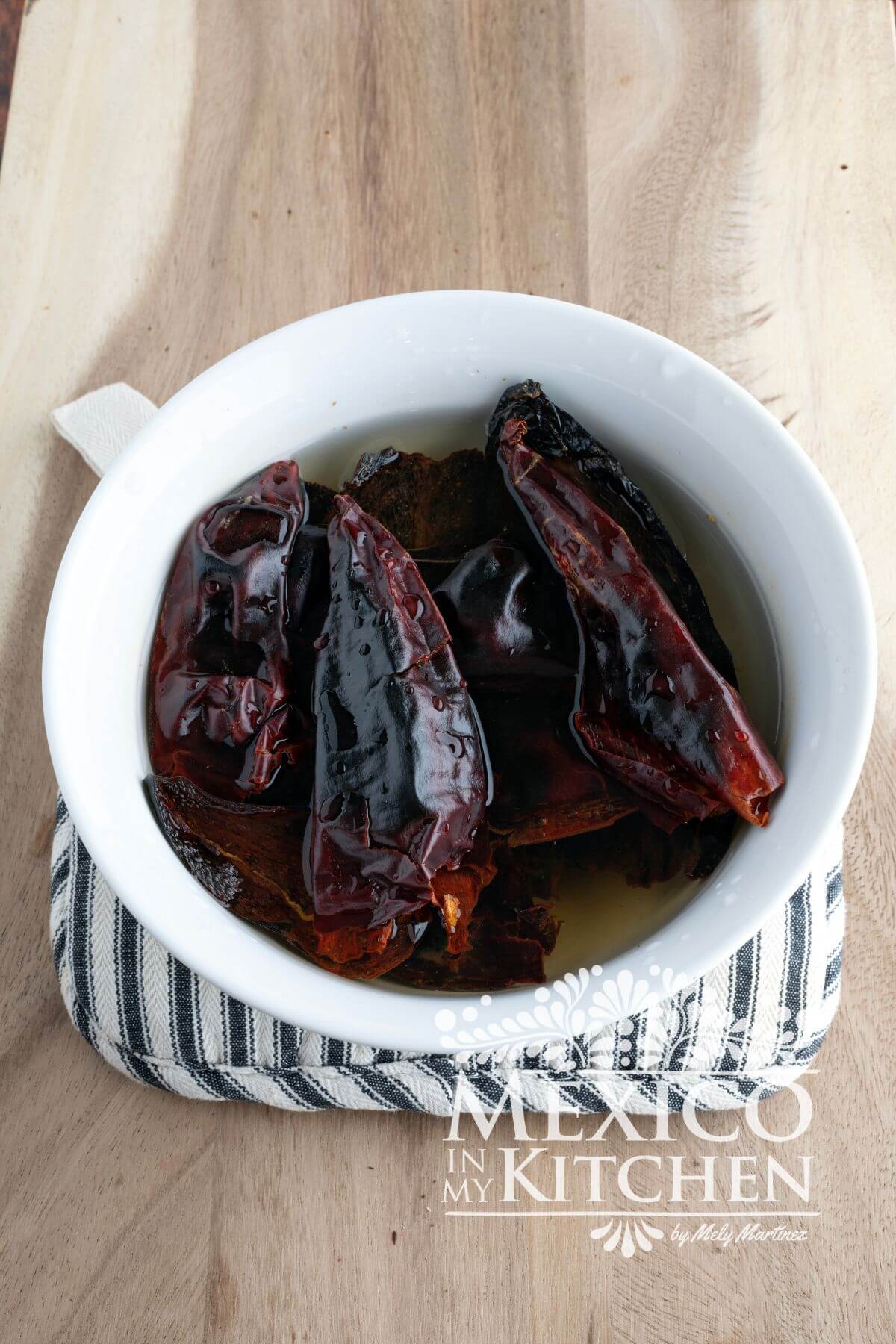Roasted dried peppers soaked in a bowl with water.