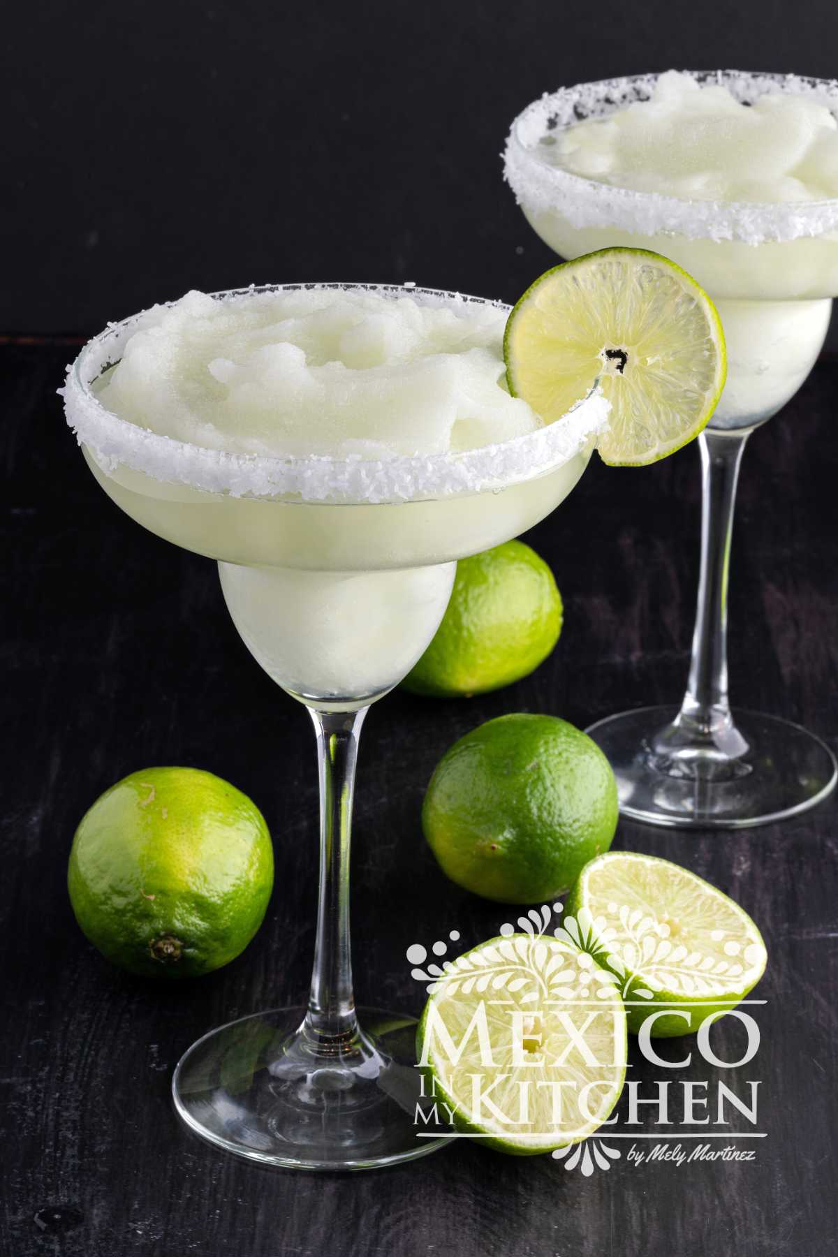 Frozen Margarita serve in a cocktail glass with slice of lime.