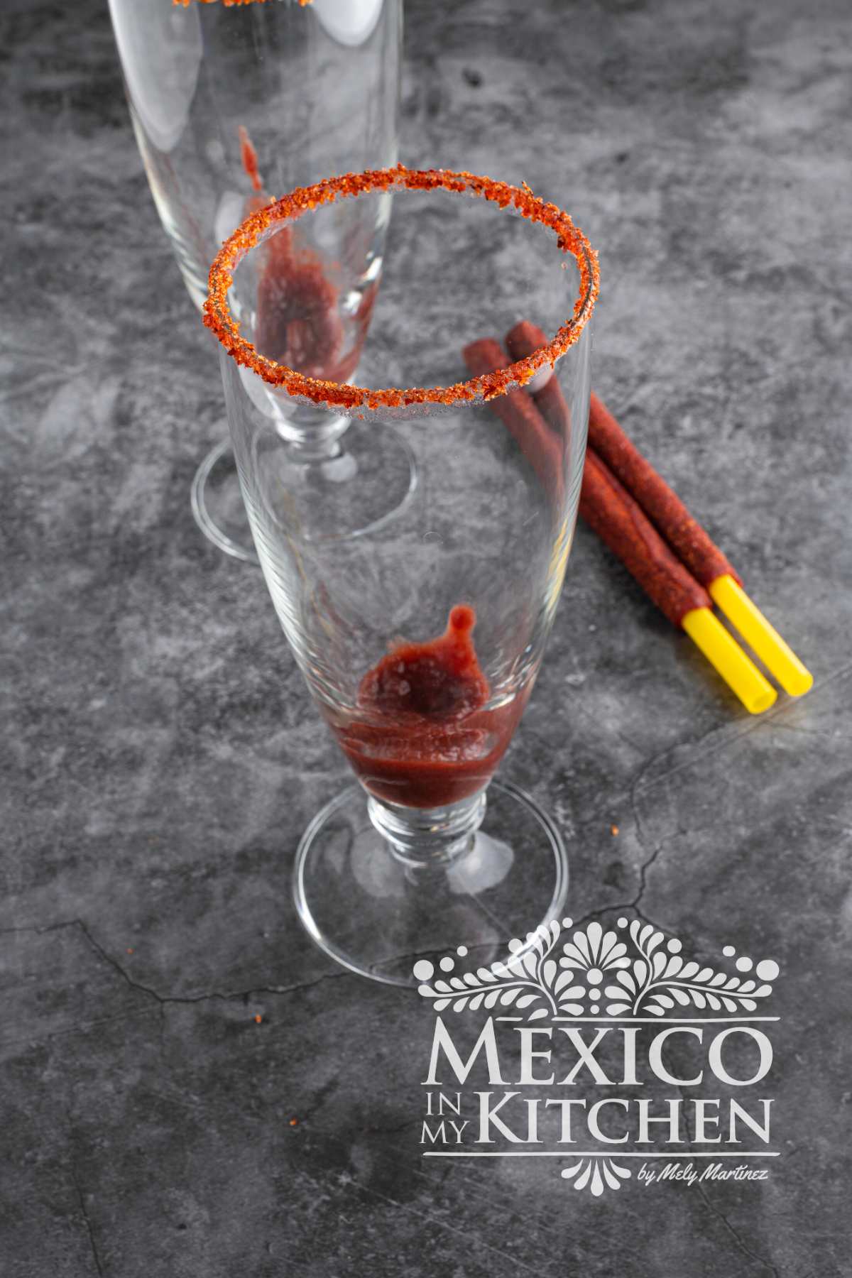 Adding Chamoy Sauce in a tall glass.