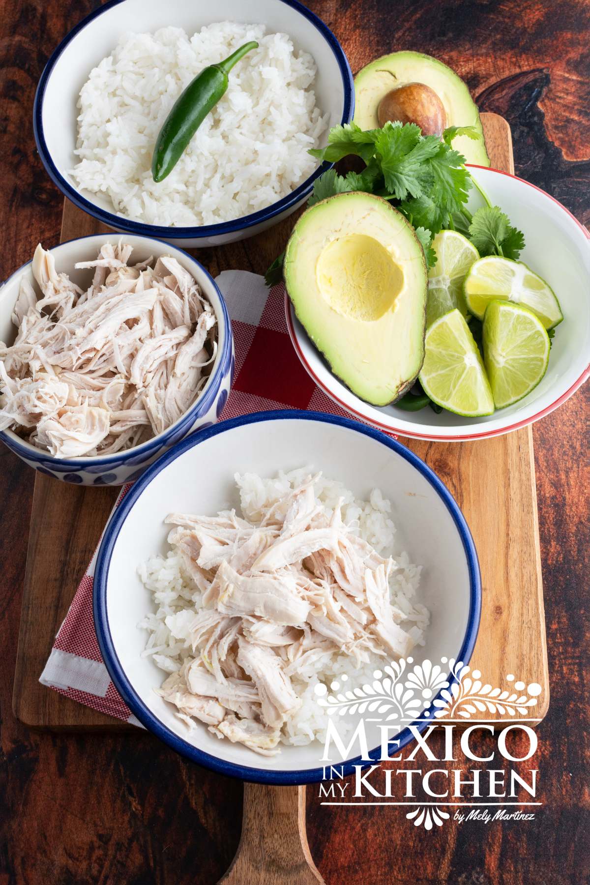Chicken and rice served in a white bowl, next to another bowl with avocado, cilantro and limes, rices, and white rice.