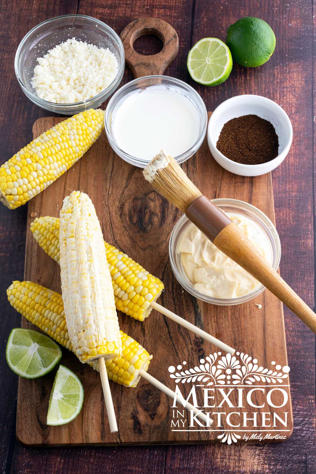 Corn on the cob with a wooden stick, cover with Mayo.