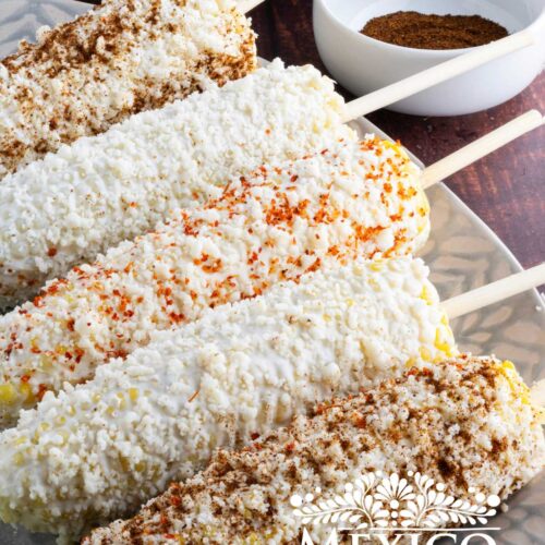 Mexican corn on the cob with different chili powder on a platter.