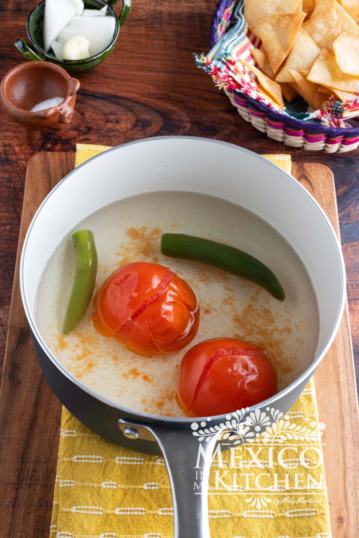 Cooked tomatoes, and peppers in a saucepan with water.