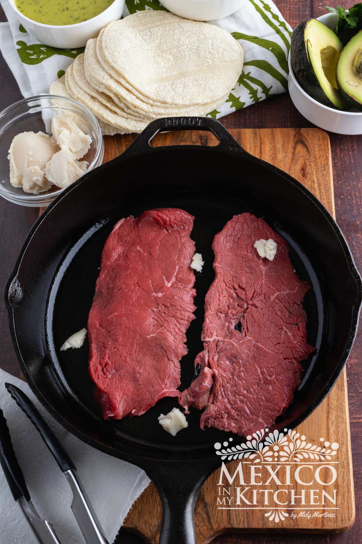 Cooking beef meat on a cast iron skillet.