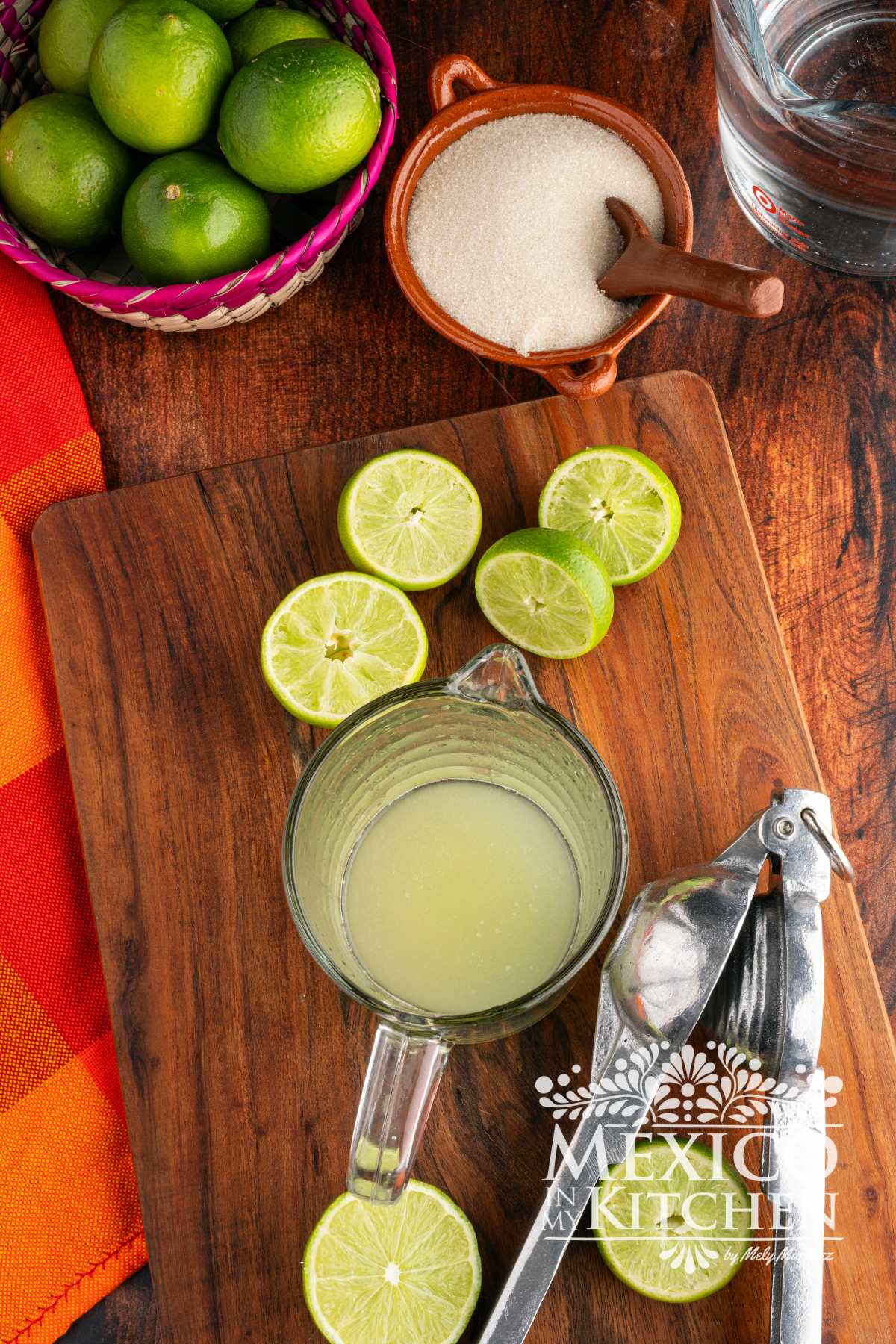 Squeezing limes into a measurement glass cup.
