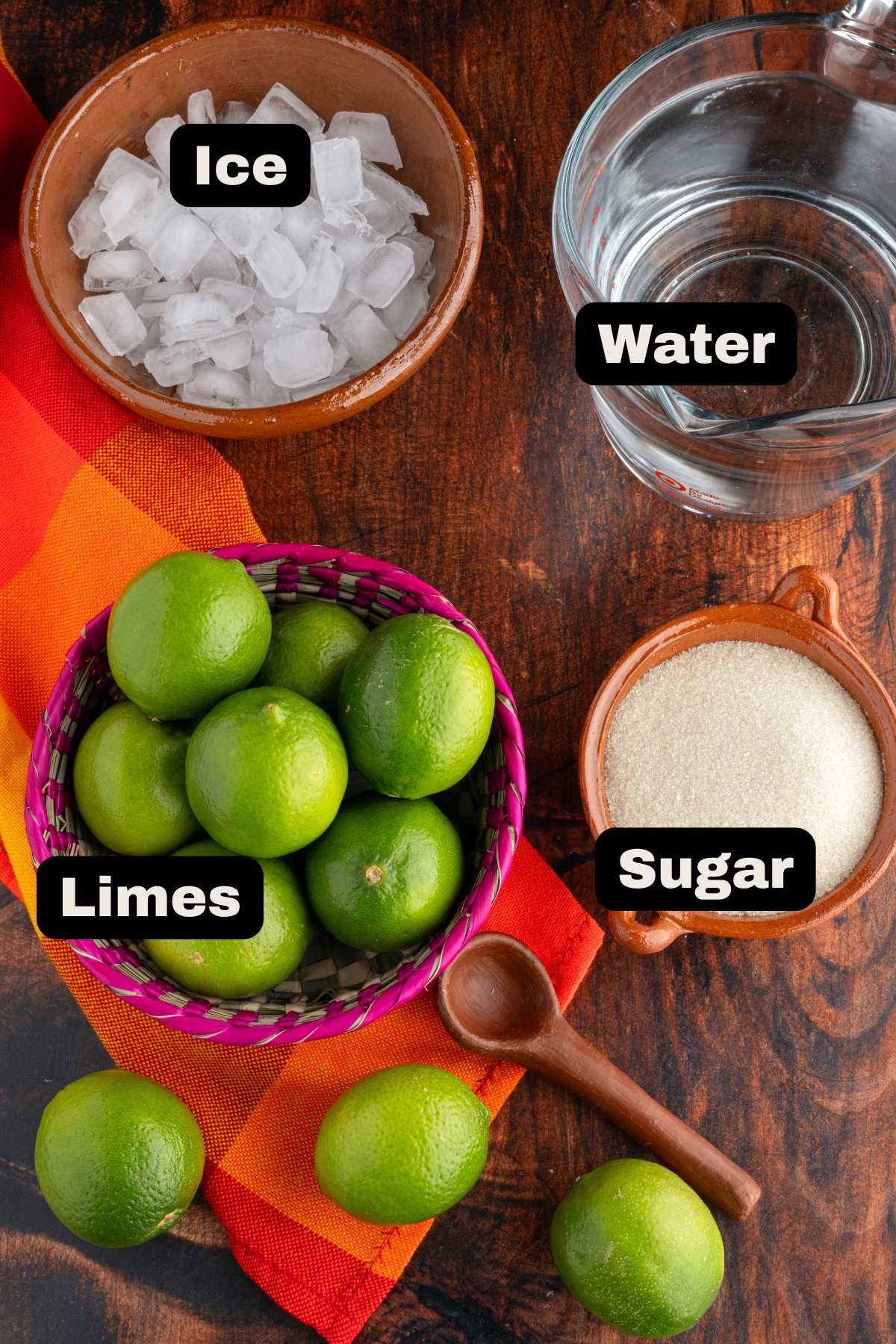 Ingredients to make agua fresca such as limes, sugar, ice and water.