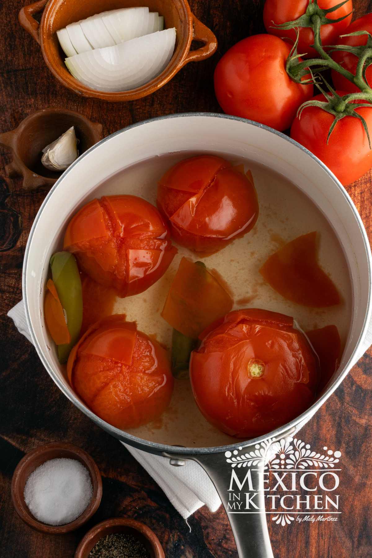 Cooked tomatoes, and serranos in a sauce pan.