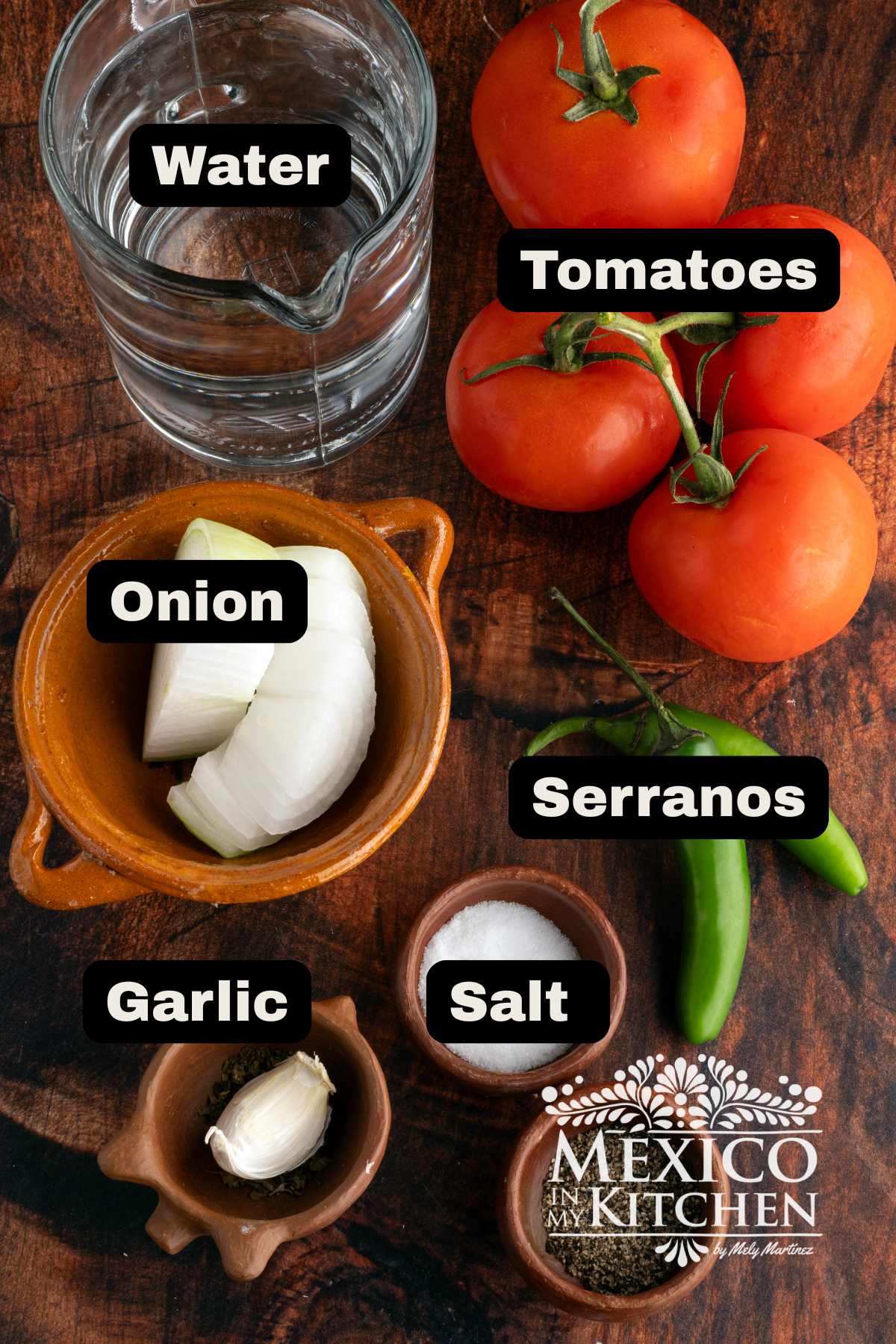 Ingredientes such as tomatoes, onions, garlic, serranos, water, and salt on a table.