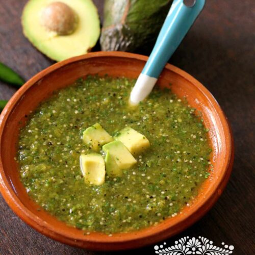 Roasted Tomatillo Salsa serve in a clay bowl.