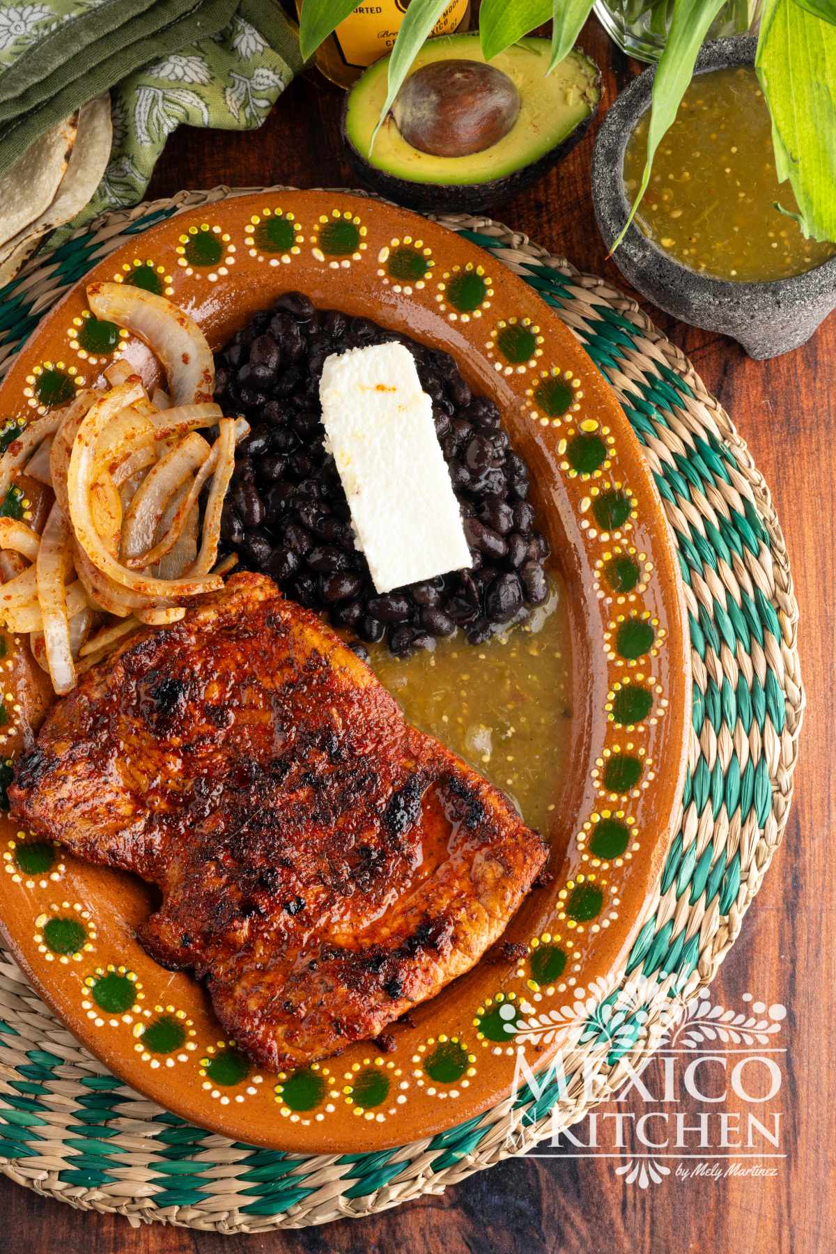 Carne enchilada serve in a platter with black beans, and queso fresco.