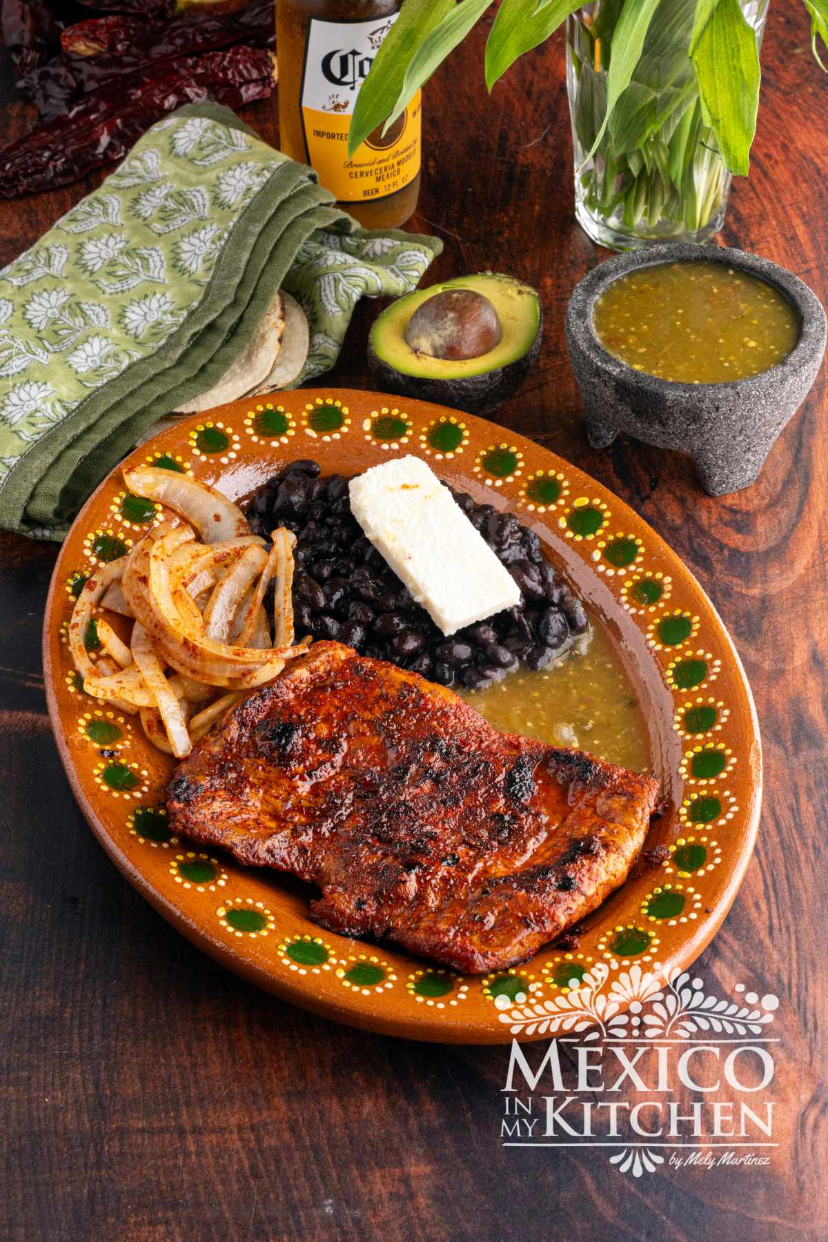 Carne enchilada serve in a platter with black beans, and queso fresco.