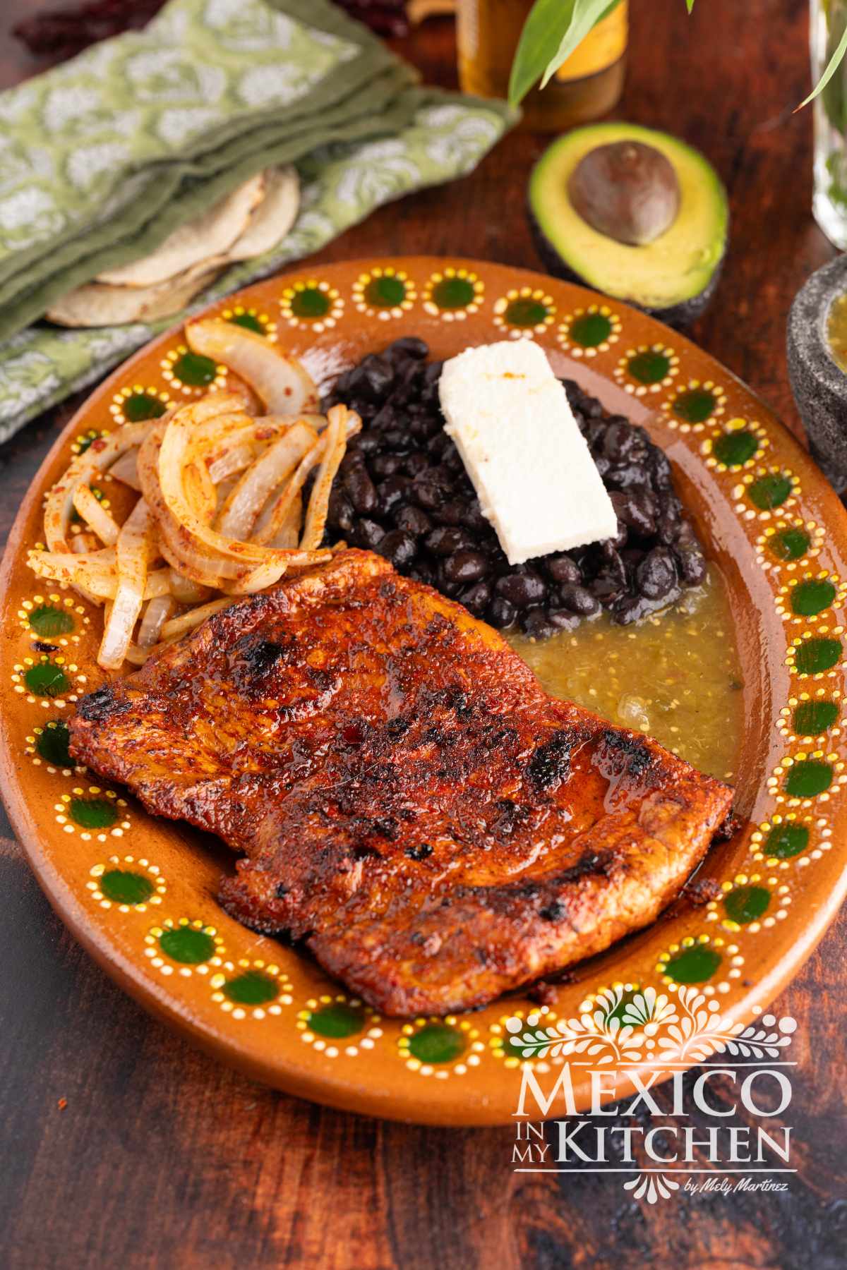 Carne enchilada serve in a platter with black beans, and queso fresco.