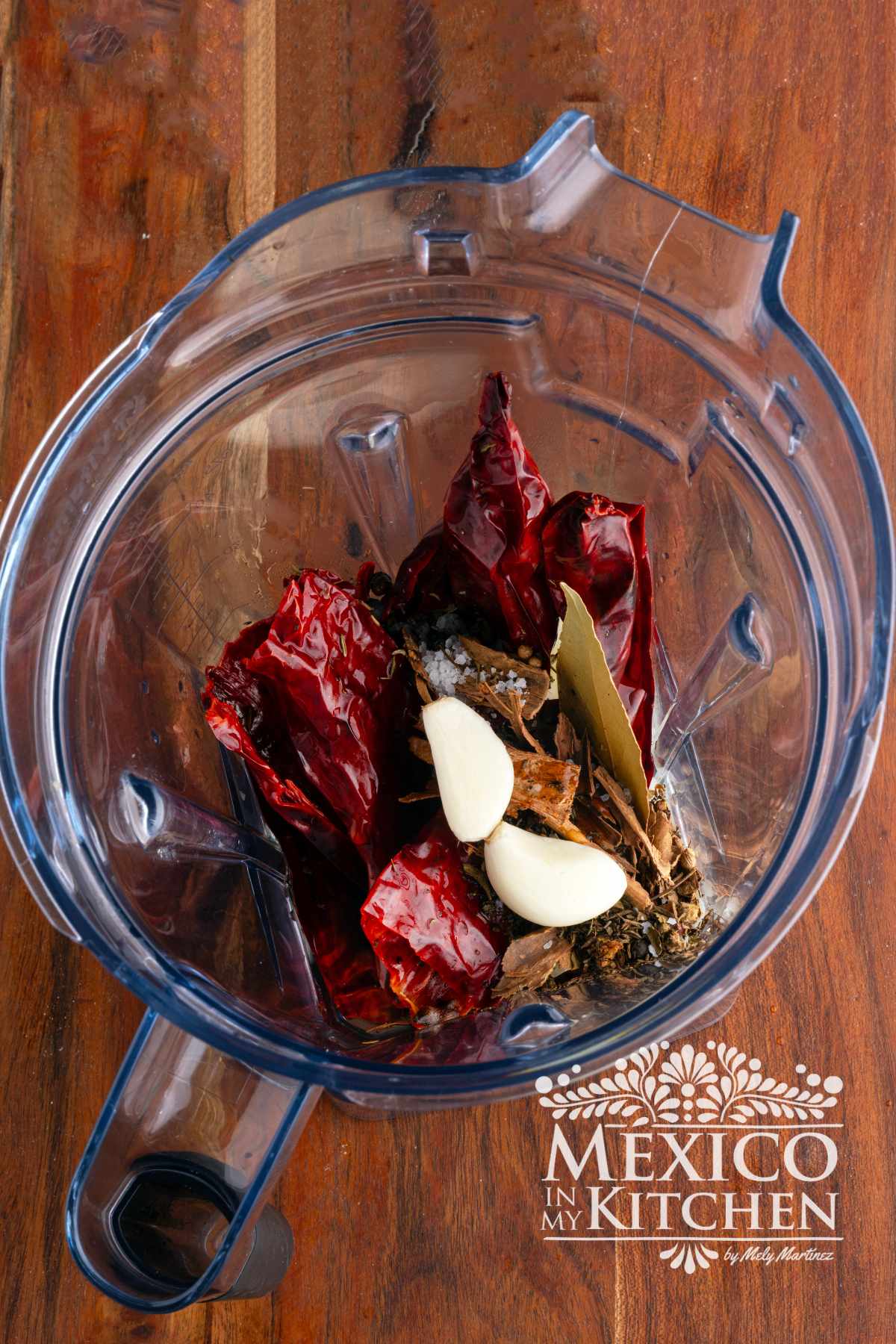 Cleaned and toasted guajillo peppers with spices in a blender.