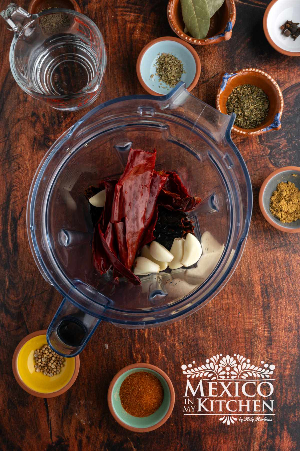 Blending soaked guajillo and ancho peppers, with spices, garlic, and vinegar in a blender